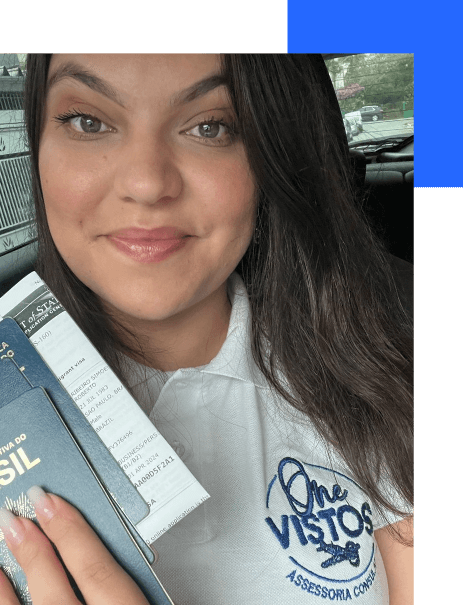 Membro da empresa One Vistos sorrindo e segurando um passaporte americano